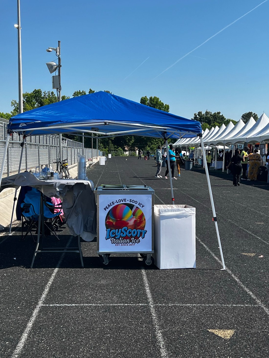 IcyScott Italian ice cart set up under a tent at an outdoor Charlotte event